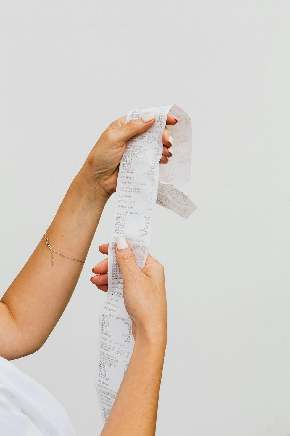 a woman holding up a receipt