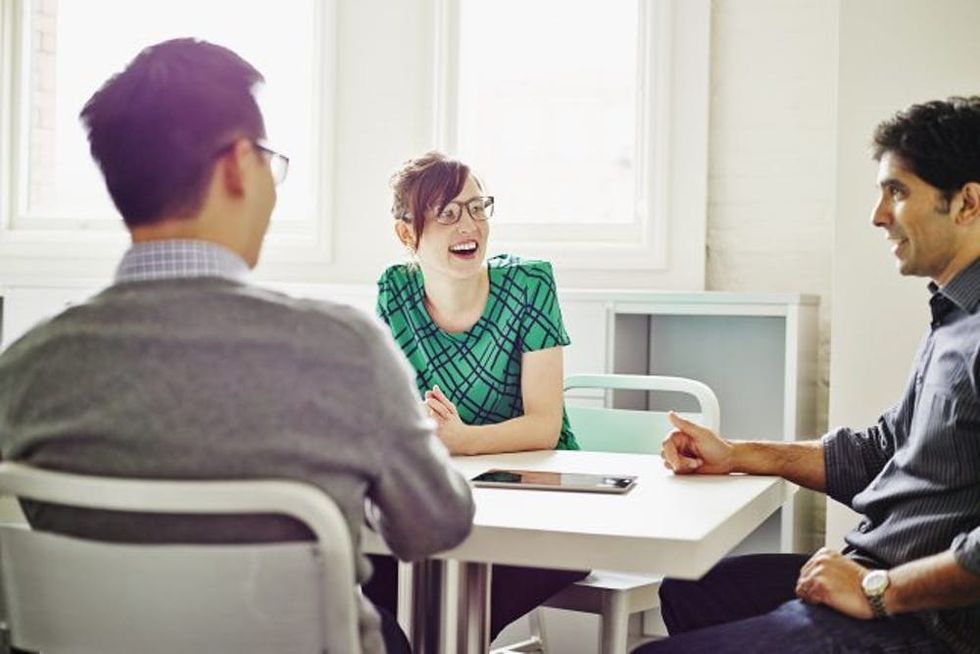 A woman laughs with coworkers