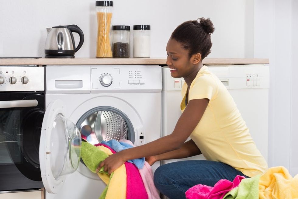 A woman loads her washer with clothes