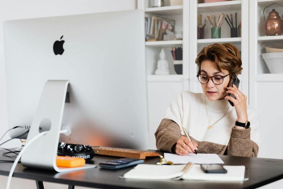 a woman on the phone and working on her computer