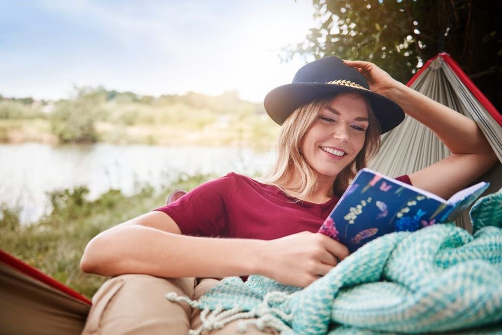 A woman relaxes with a book in a hammock