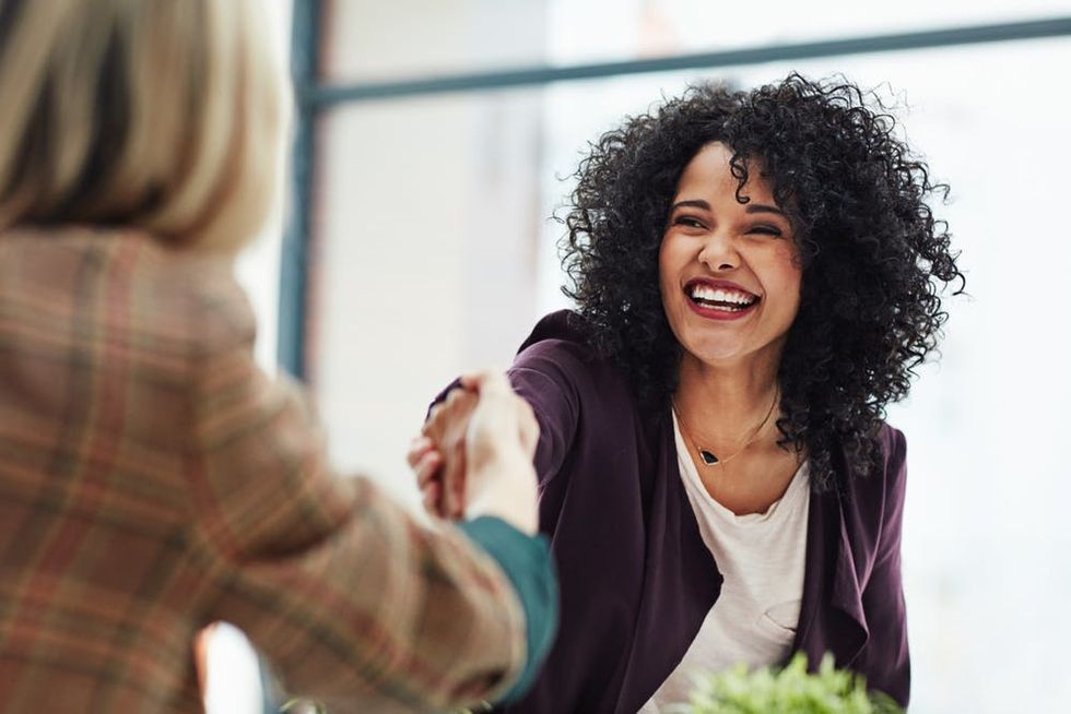 A woman shakes a colleague's hand