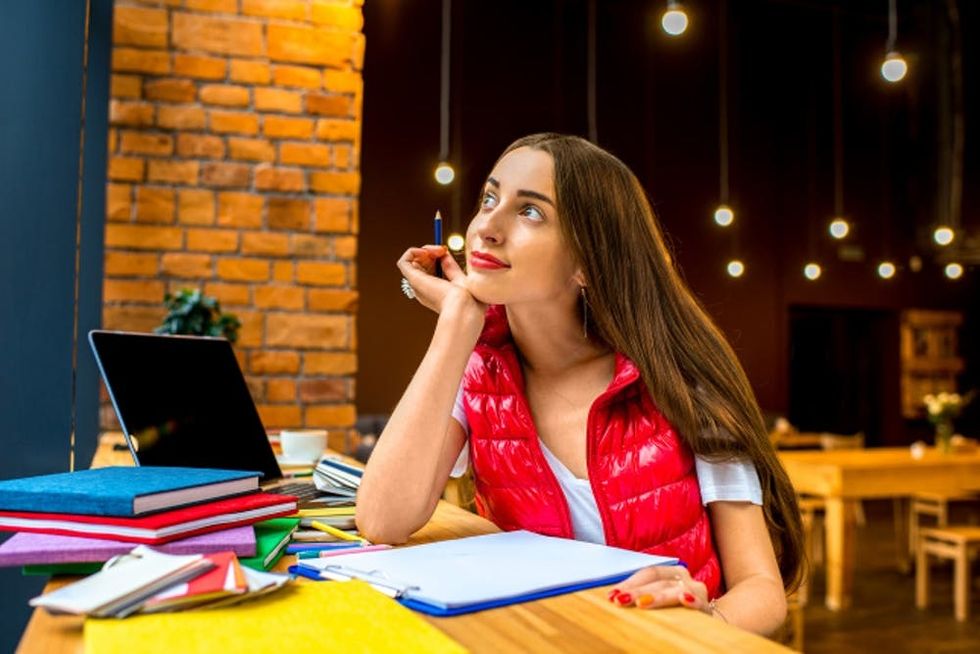 A woman sits and thinks in a cafe