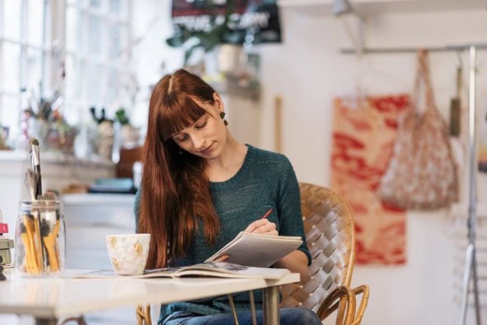 A woman sketches at a table