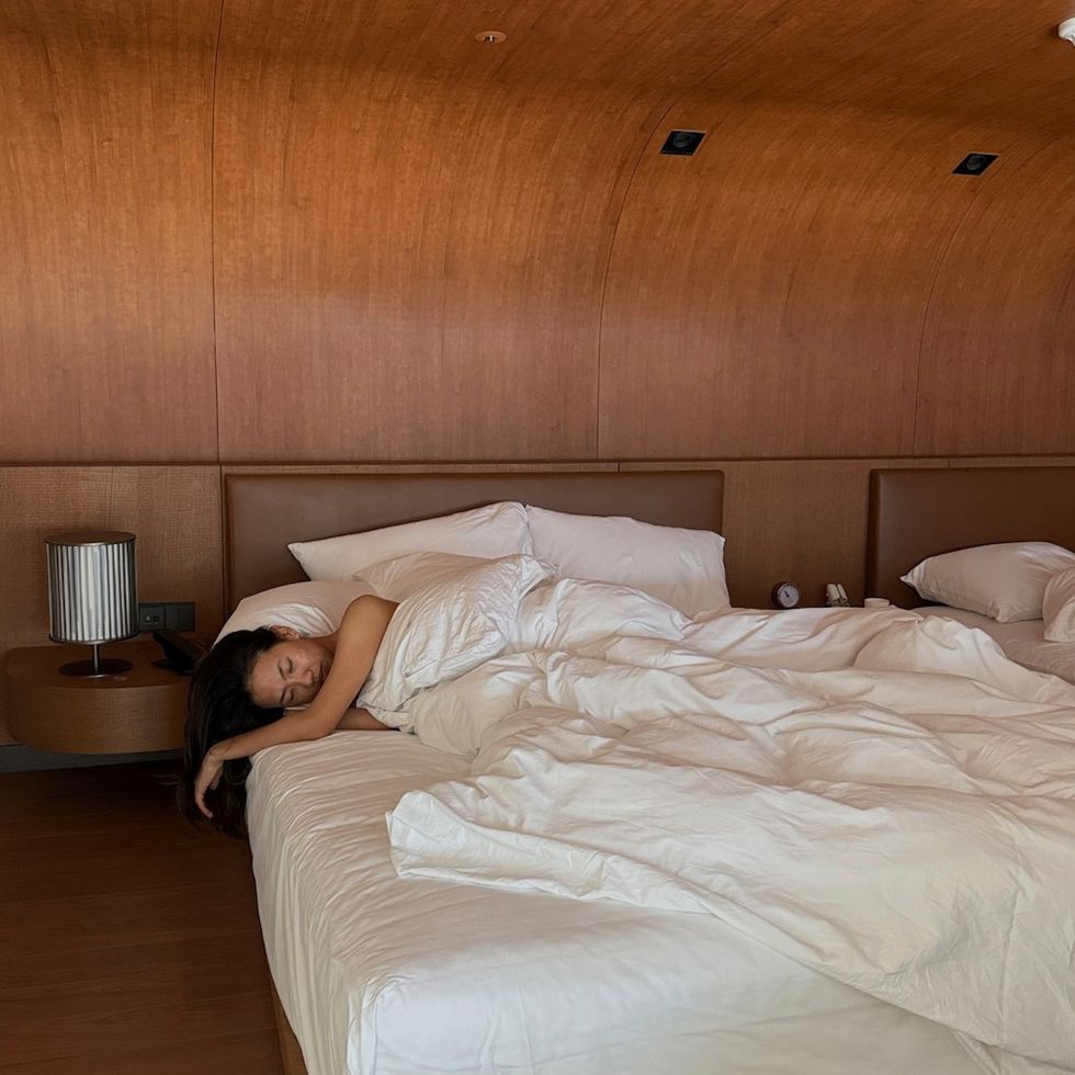 a woman sleeping in a hotel bed