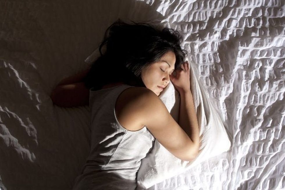 A woman sleeps peacefully in her bed