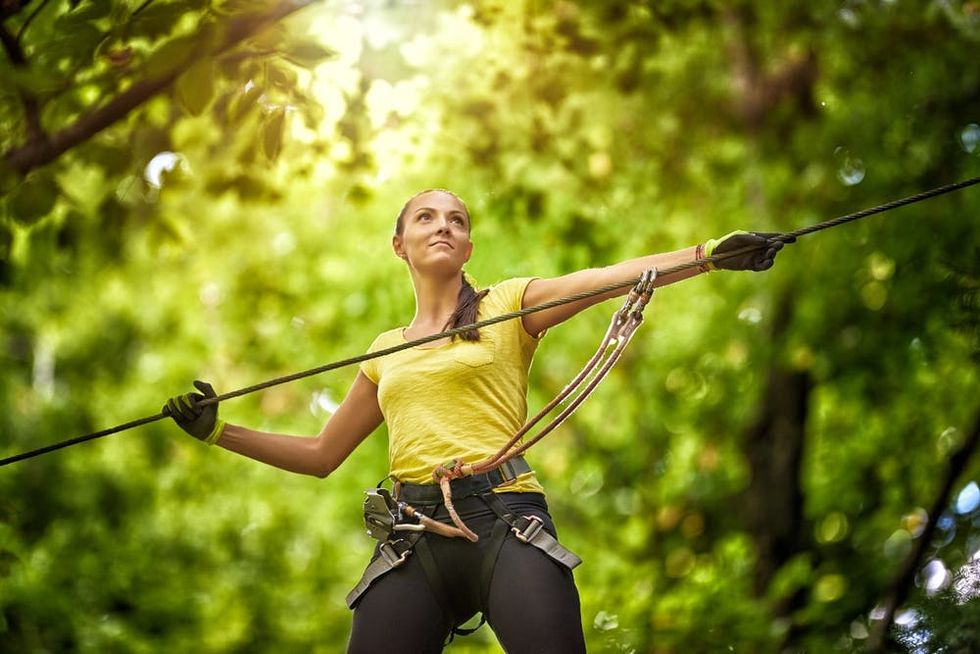 A woman stands by a zipline