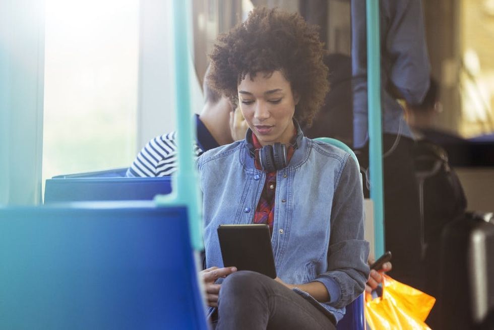 A woman uses a tablet during her commute