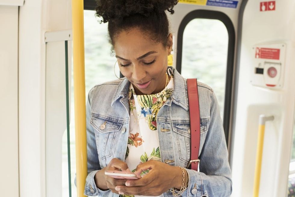 A woman uses her phone on a train