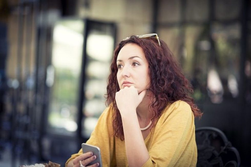 A woman waits alone at a cafe