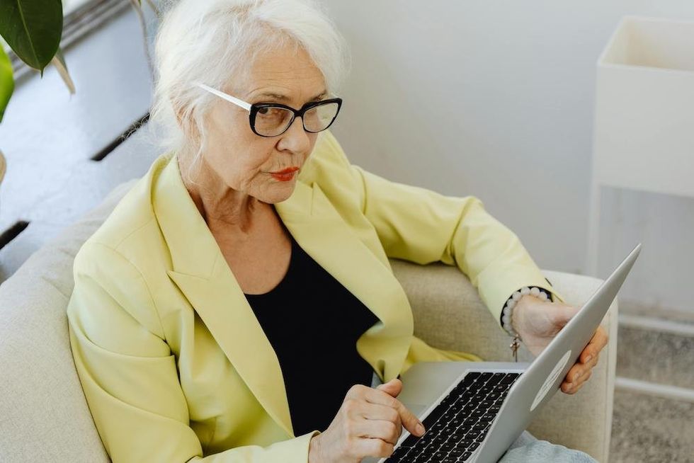 a woman wearing glasses and working on her laptop