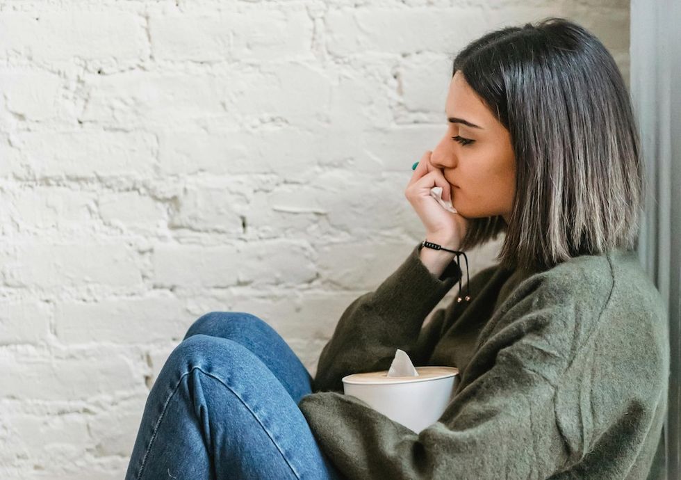 a woman who's sick with a box of tissues