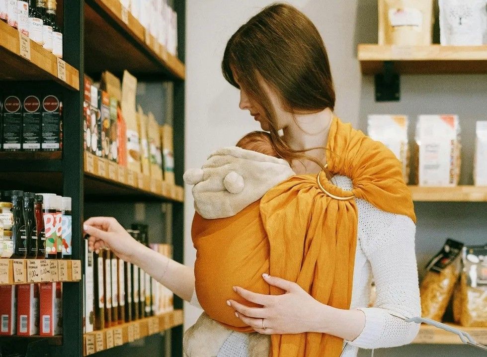 a woman with her baby going grocery shopping