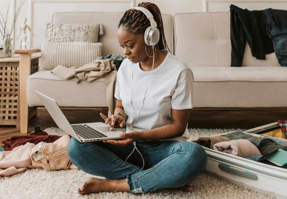 a woman working in the middle of her messy room