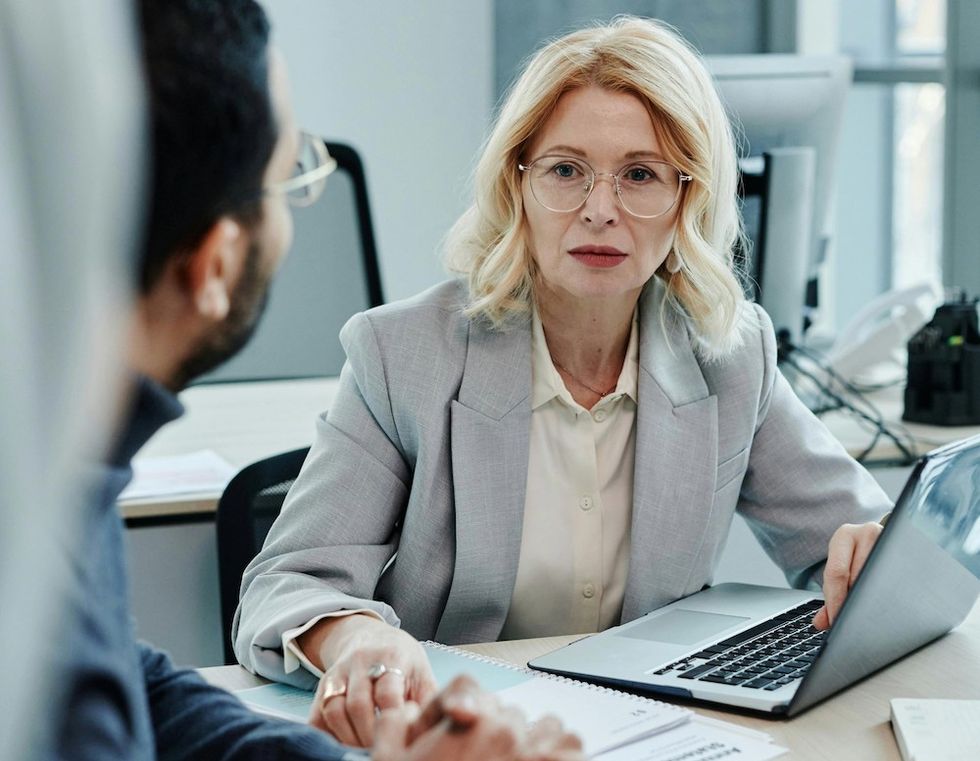a woman working on her laptop in a meeting at work