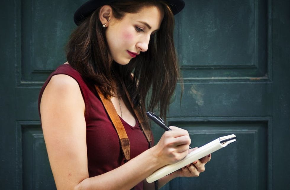 A woman writes in a notebook