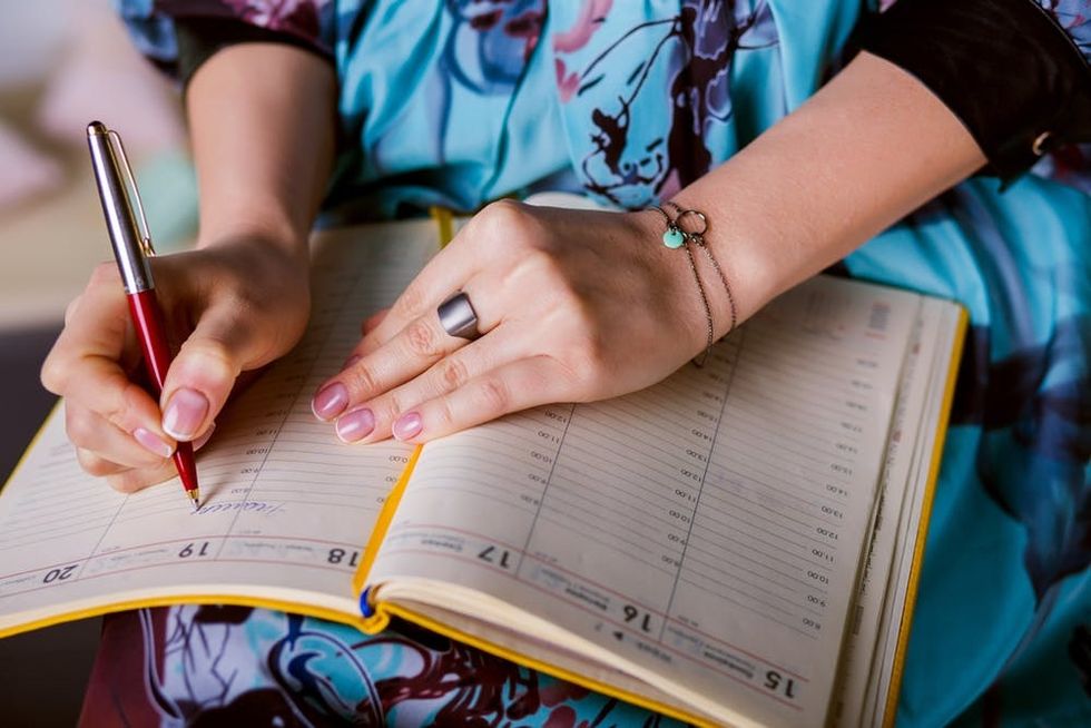 A woman writes in a planner