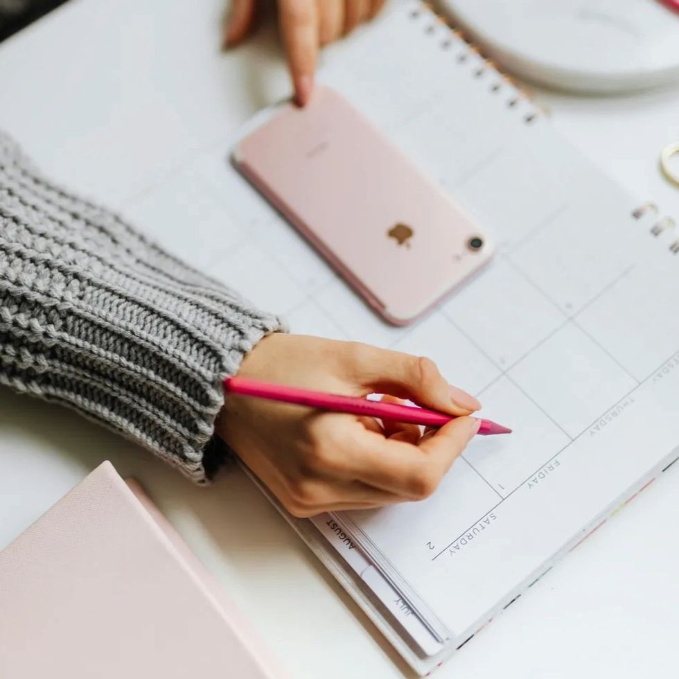 a woman writing in a calendar