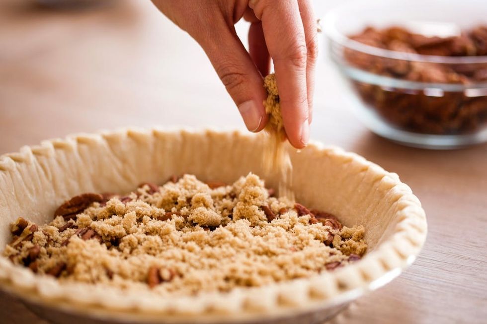 adding brown sugar to the pecan layer of our pumpkin pie recipe