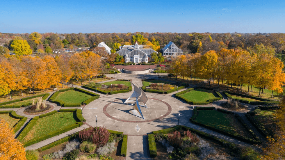 Aerial view of a geometric garden with fall foliage and a glass conservatory.