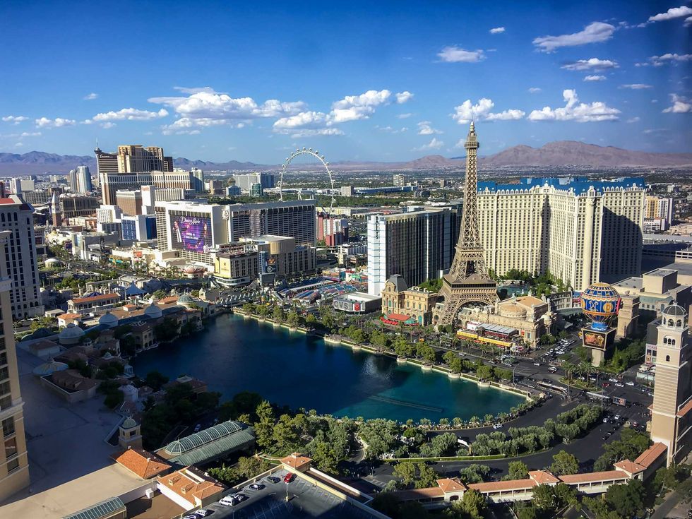Aerial view of Las Vegas Strip with hotels, Eiffel Tower replica, and Ferris wheel.