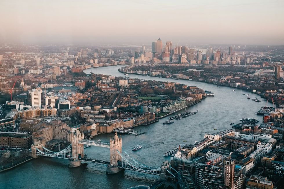 Aerial view of London with the Thames and iconic Tower Bridge at sunset.