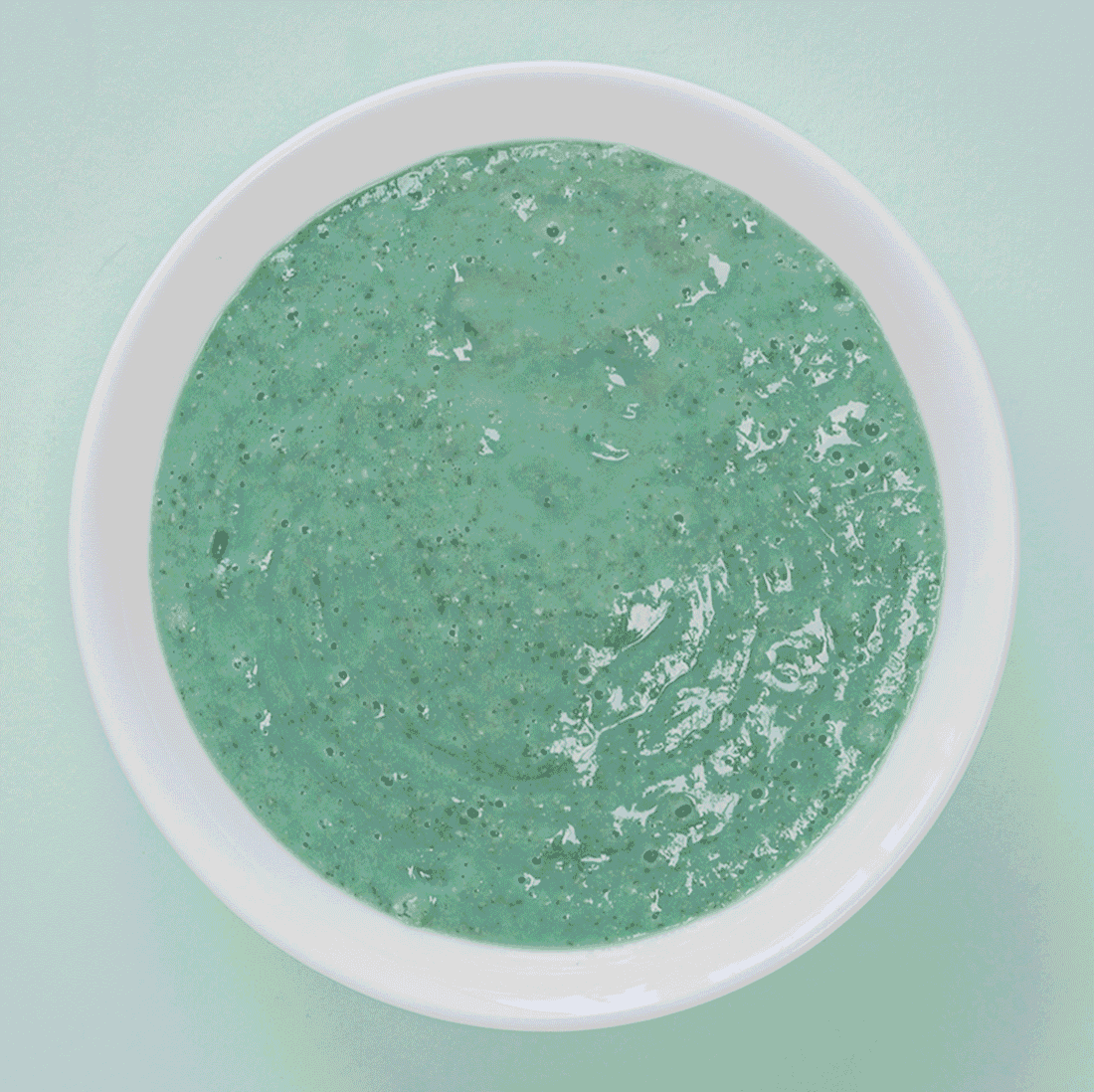 aqua colored smoothie bowl with seeds and fruit