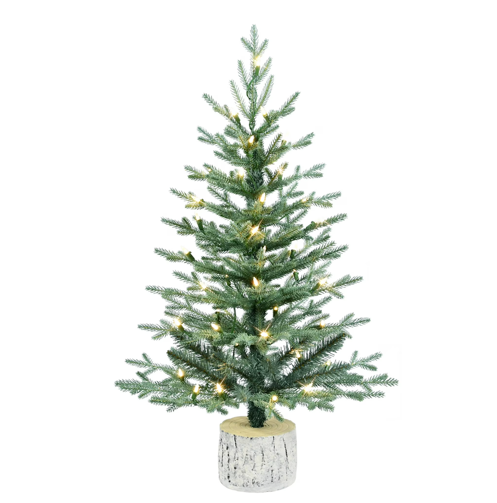 Artificial Christmas tree with lights in a birch-style pot.