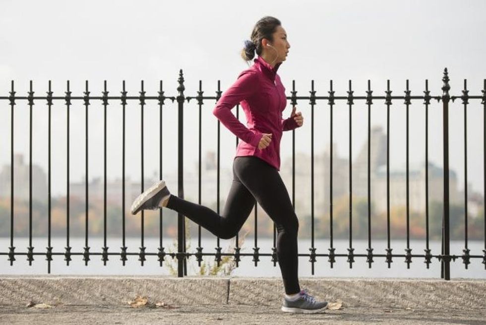 Asian woman running on waterfront path