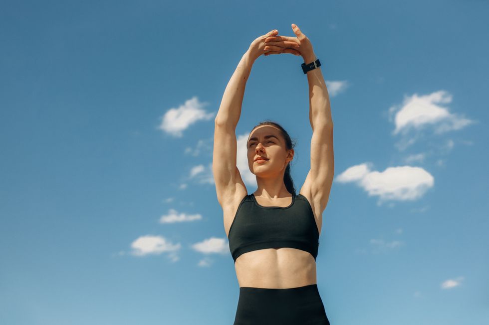 athletic woman in black outfit stretching for rest days