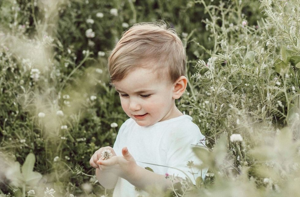 baby boy sitting in wildflowers