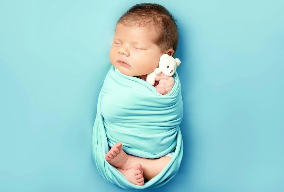 baby boy swaddled with a light blue blanket