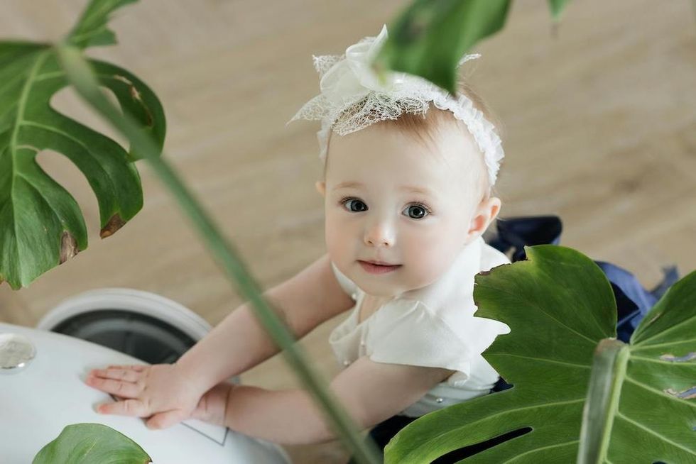 baby by a green plant