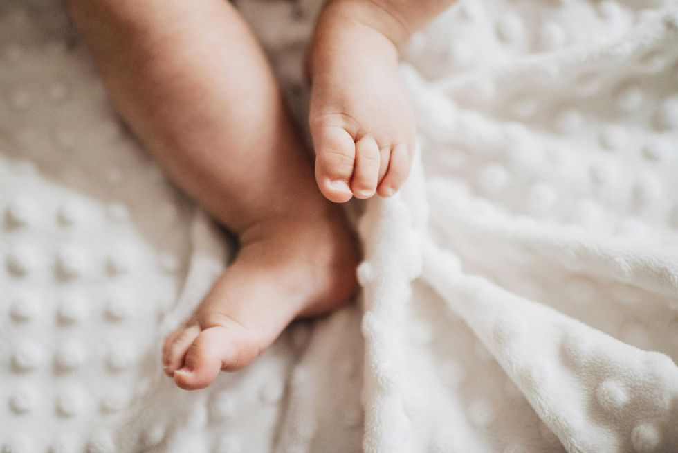 Baby feet on a soft white blanket.