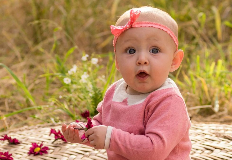 baby girl holding flowers