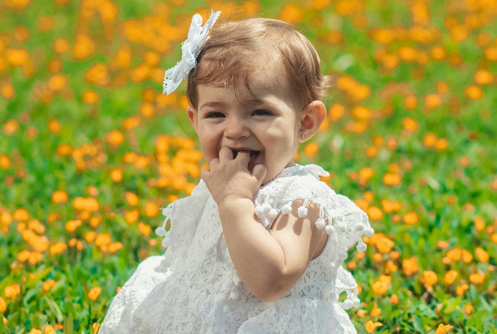 baby girl sitting in a field of orange flowers