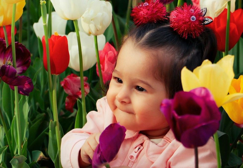 baby girl sitting in tulips