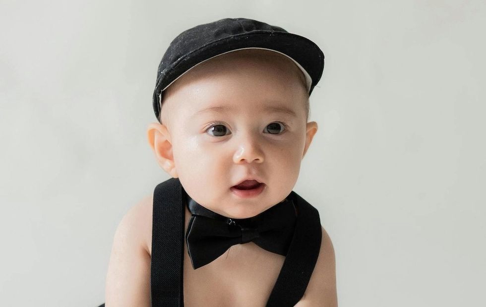 baby in a bowtie, suspenders, and a hat