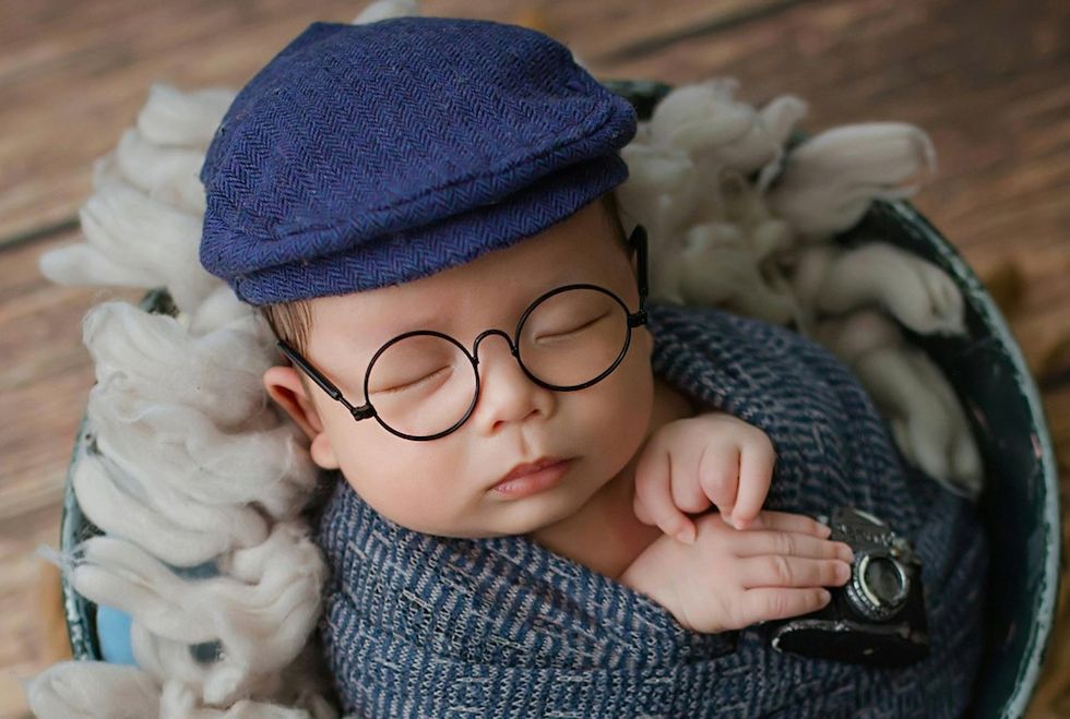 baby in a hat and glasses, swaddled