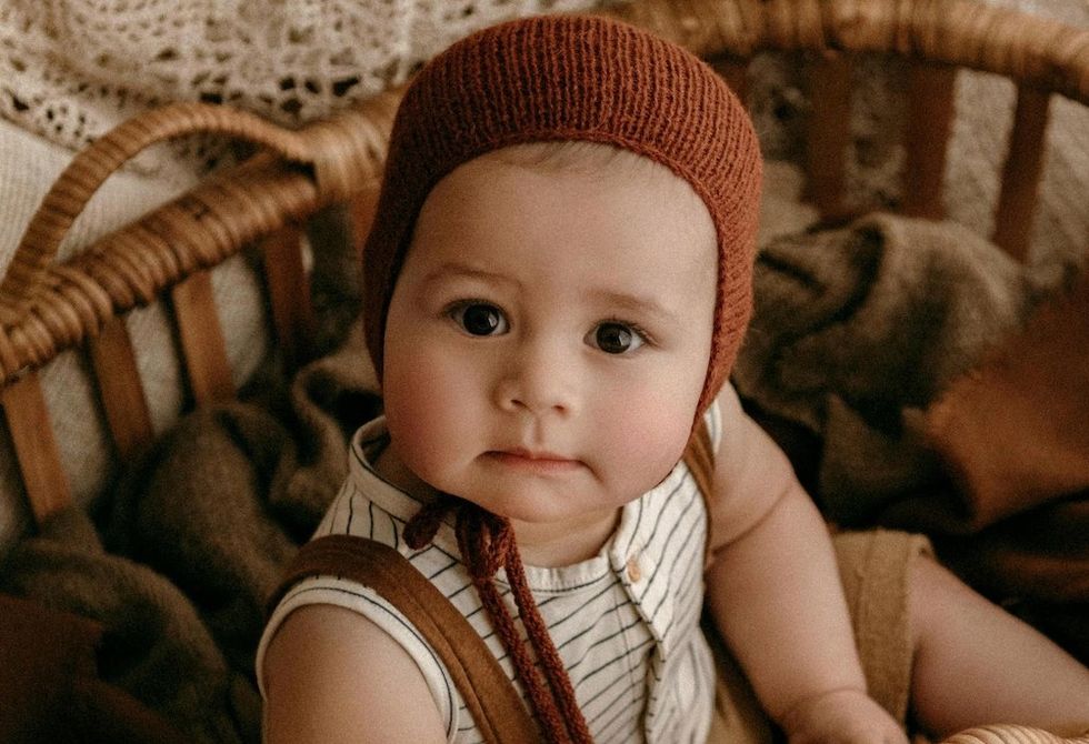 baby in a red bonnet
