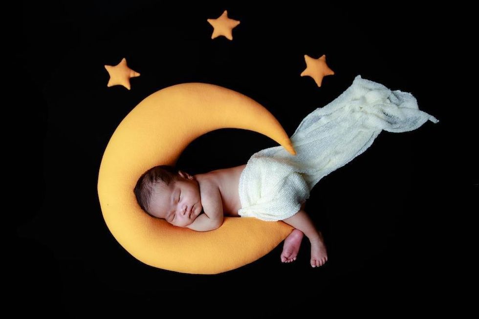 baby laying on a moon pillow