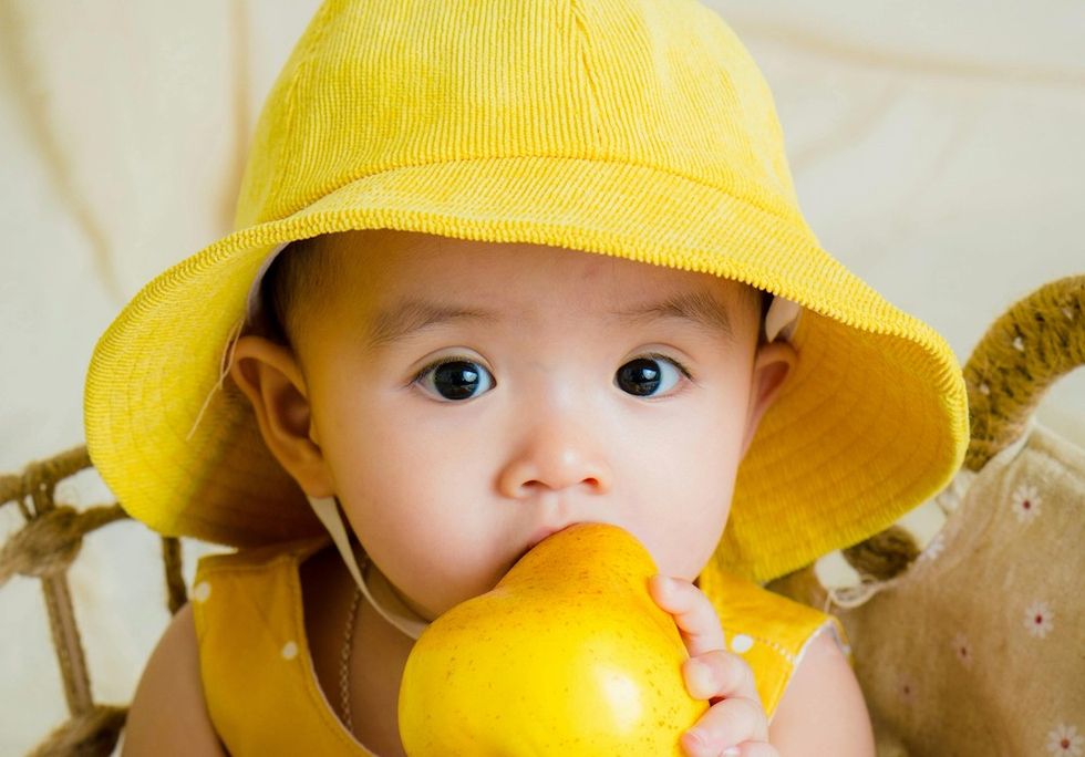 baby posing with a pear