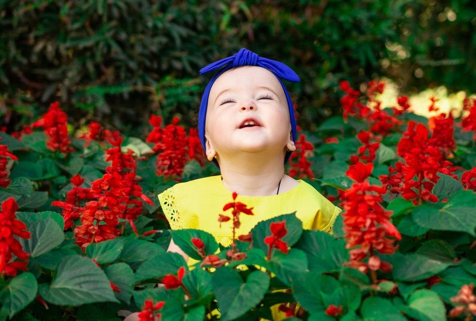 baby sitting in red flowers