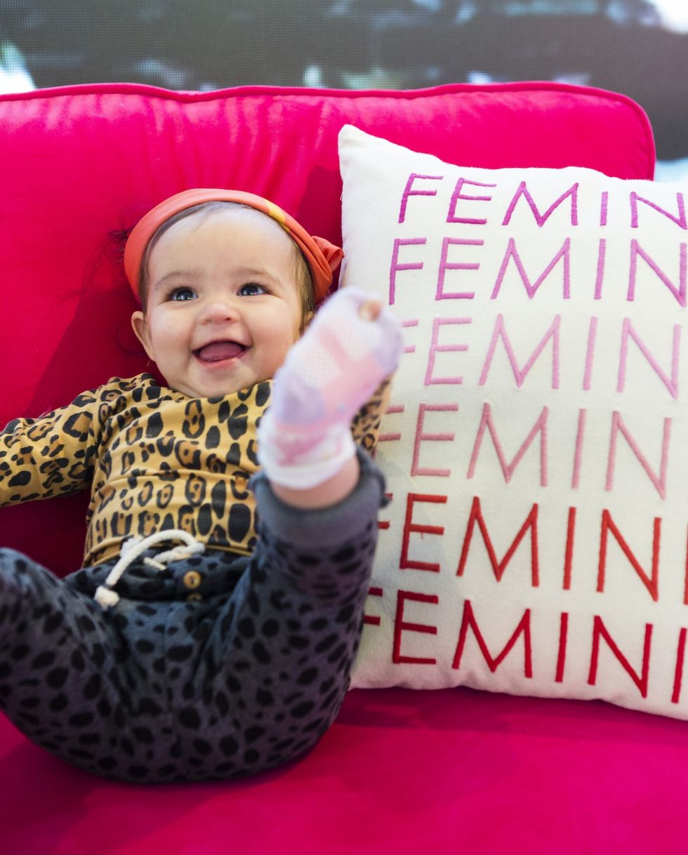 baby sitting on a pink chair