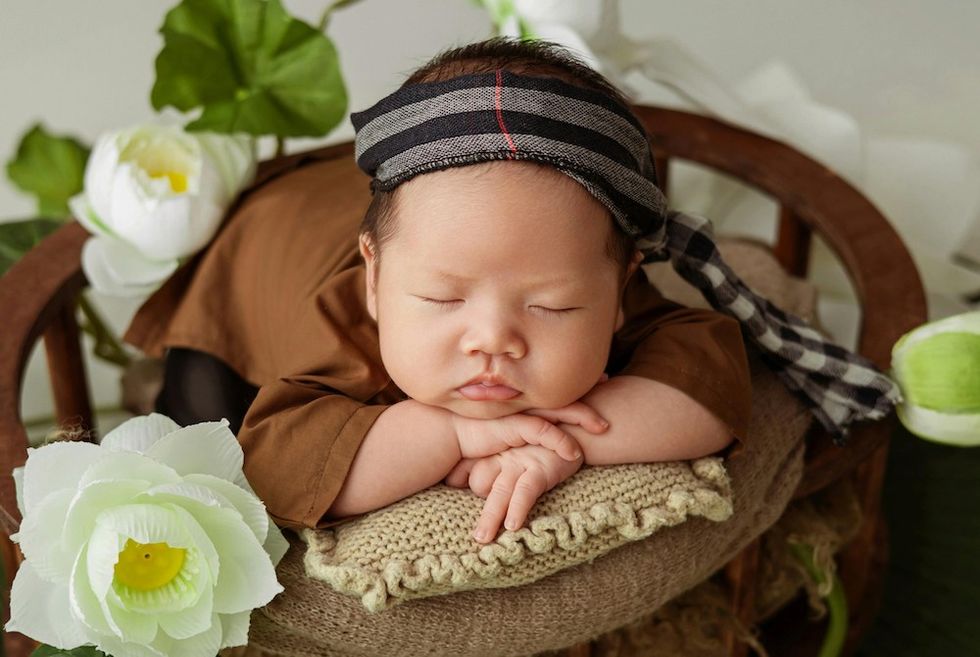 baby sleeping surrounded by flowers