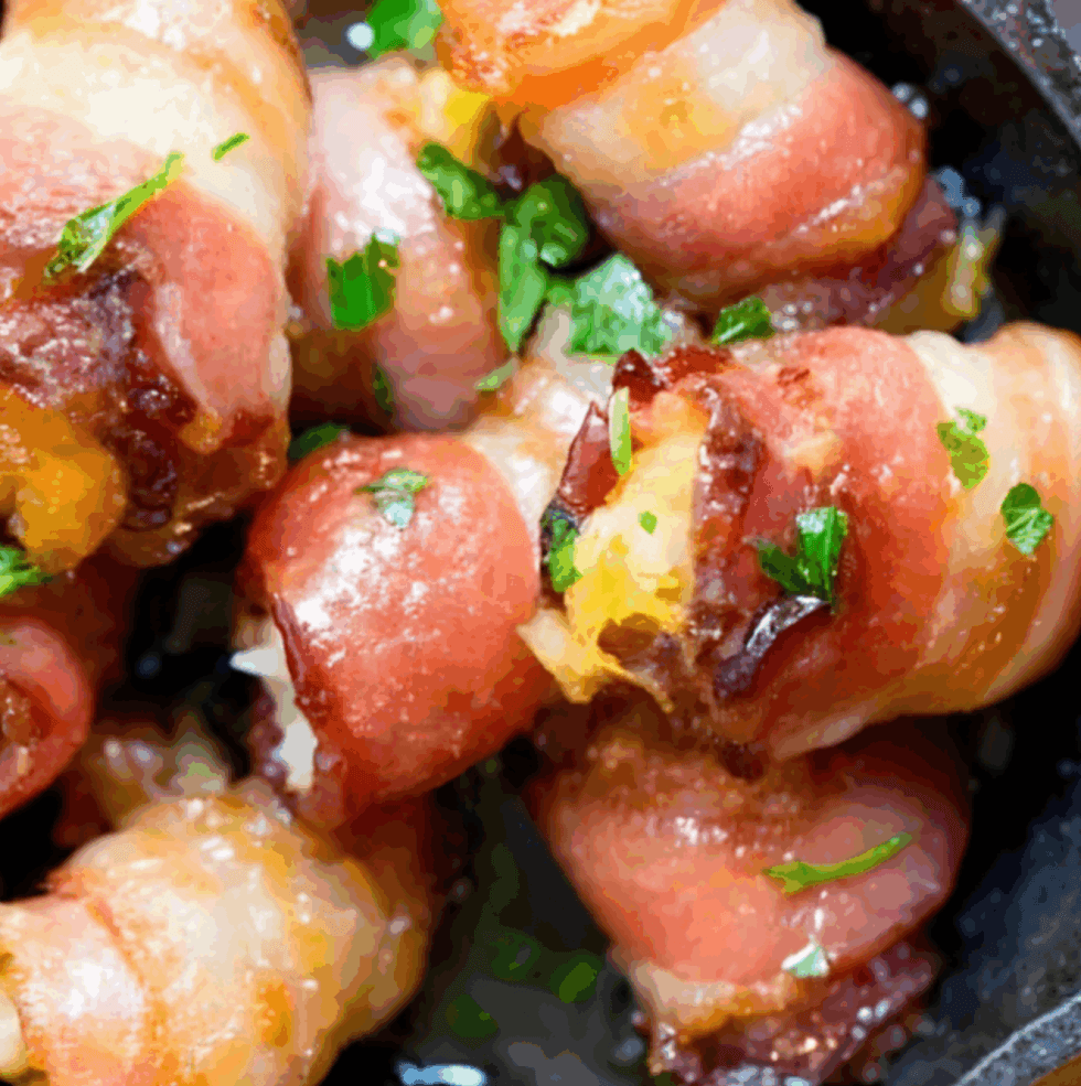 Bacon-wrapped dates with garnished herbs in a close-up shot.
