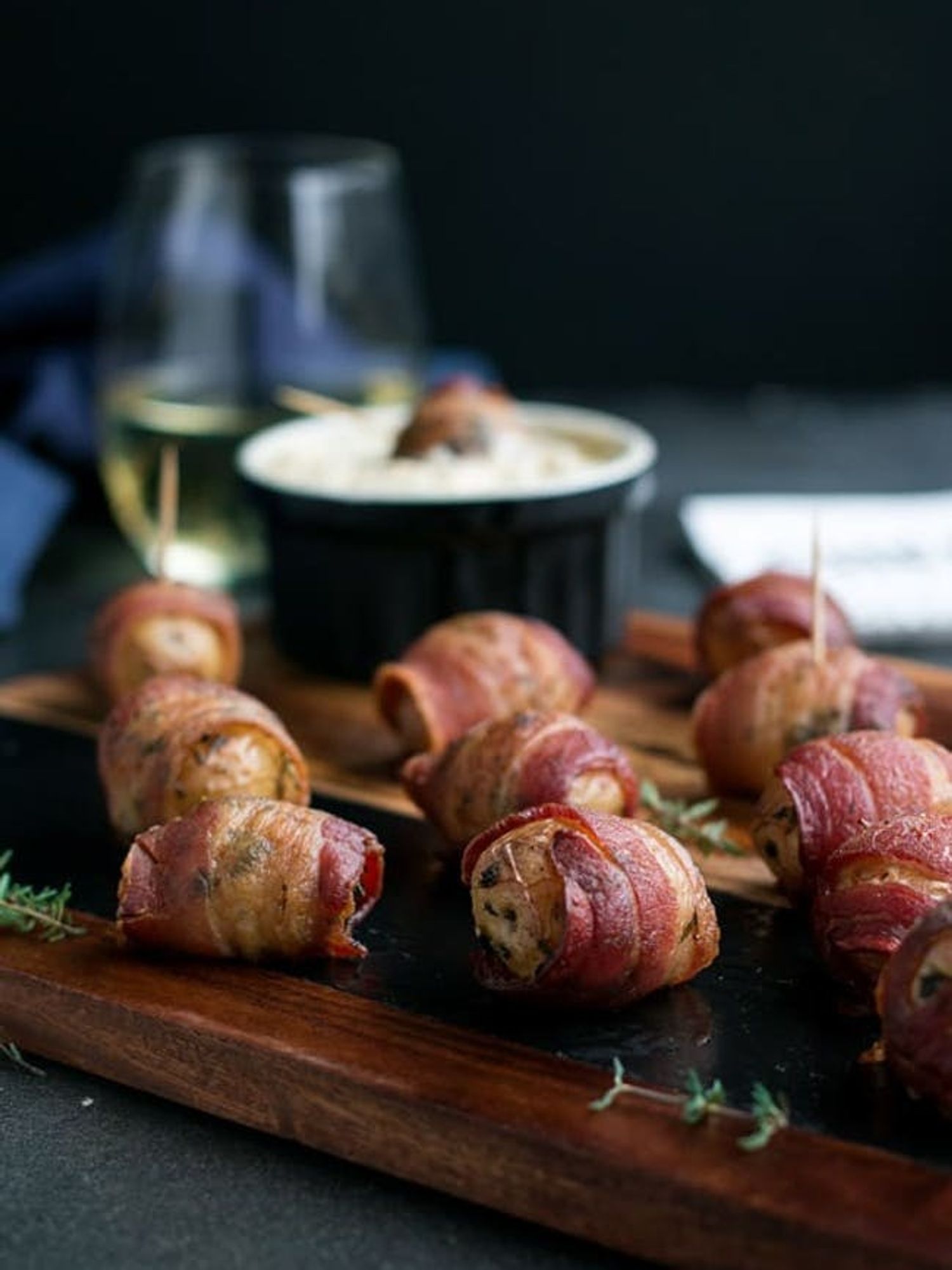 Bacon Wrapped Potatoes With Warm Apple Cream Cheese Dip on a wooden chopping board