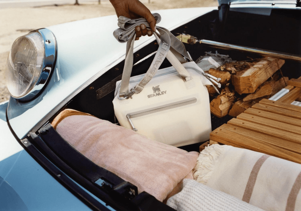Bag and wood in vintage car trunk on a sunny day.