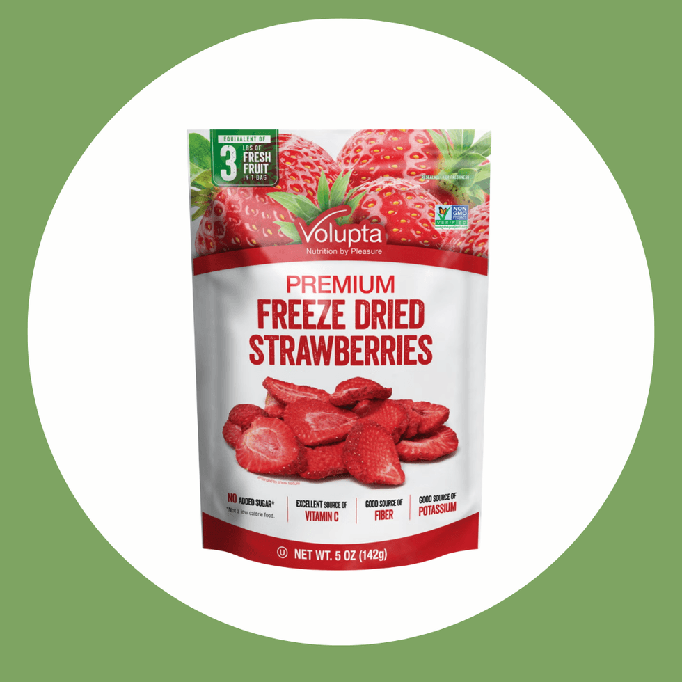 Bag of Volupta premium freeze-dried strawberries on a green background.