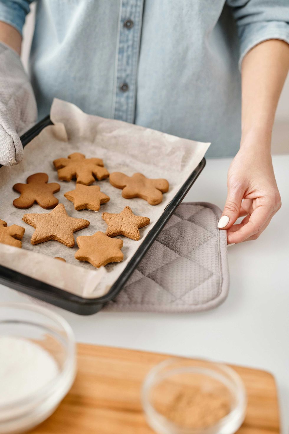Baking tray with fresh gingerbread cookies in star and gingerbread man shapes.